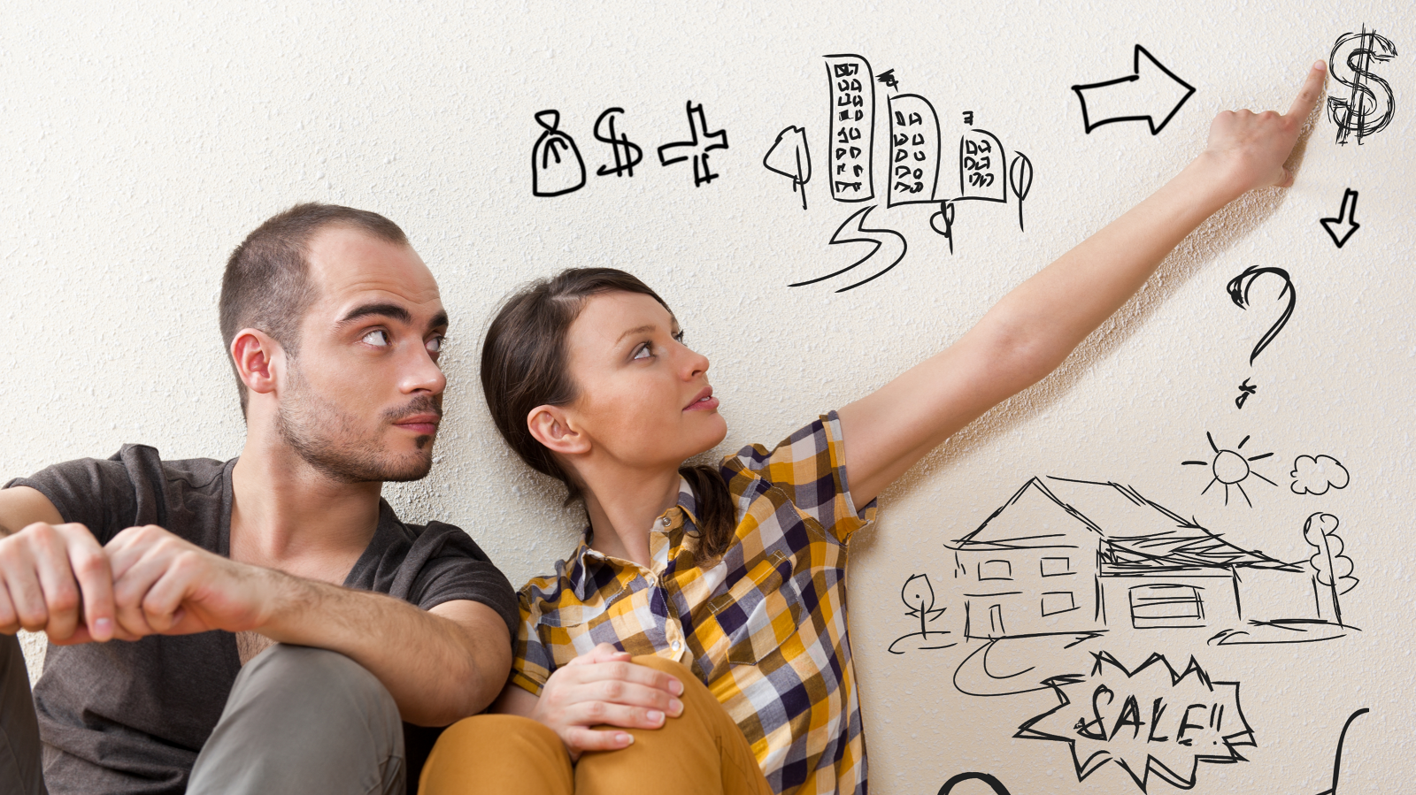 A young couple sitting against a wall looking up at hand-drawn illustrations of money, buildings, a house with a sale sign, and question marks